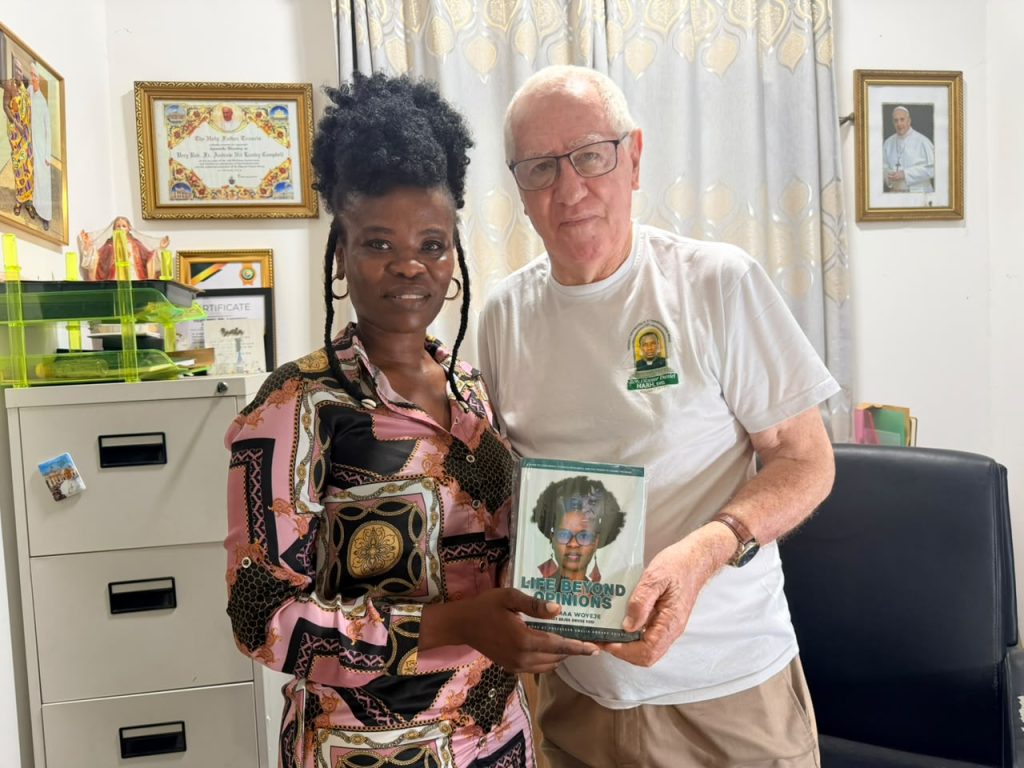 Ohemaa Woyeje presenting her book Life Beyond Opinions to Rev. Father Andrew Campbell